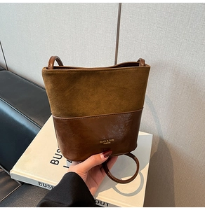 Detailed close-up of brown patchwork bucket bag featuring matte and glossy leather textures