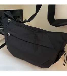 Dettaglio borsa a mezzaluna in nylon nero con tracolla regolabile e texture