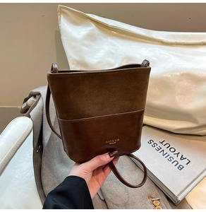 Detail of brown patchwork bucket bag with suede and smooth leather textures