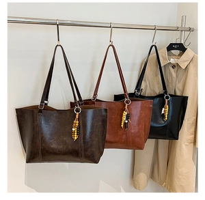 Three vintage leather tote bags in brown and black with unique beaded tassel details