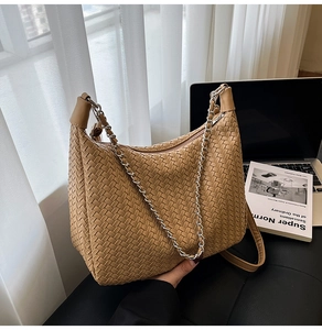 Macro shot of camel woven hobo bag with leather texture and silver chain strap