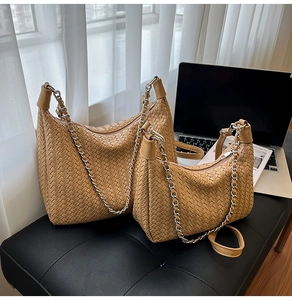 Detail of woven leather tote set in caramel brown with silver chain and adjustable straps