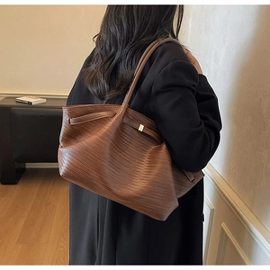 Detail of brown woven faux leather tote bag showing large capacity and shoulder straps