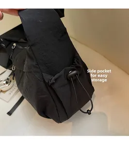 Dettaglio della tasca laterale della borsa in nylon nero con coulisse per borracce