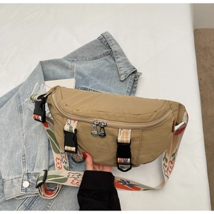 Close-up of khaki nylon crescent chest bag with colorful floral embroidery on the wide strap