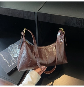 Détail du sac hobo en cuir froissé marron foncé avec finition brillante et dorures