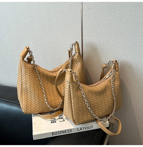 Close-up of khaki woven leather bags in two sizes featuring elegant silver chain detail