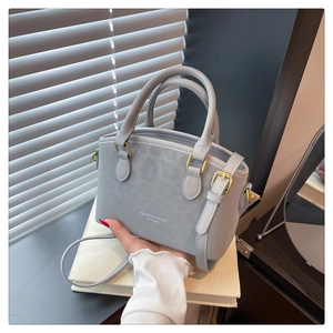 Detail of light gray frosted bucket bag with gold hardware and fashion embossing