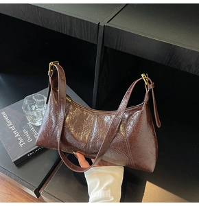 Détail du sac rétro en cuir verni plissé marron avec boucle en métal doré et fermeture