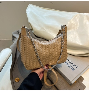 Detail showing high-quality woven texture on the camel leather hobo bag and metal chain