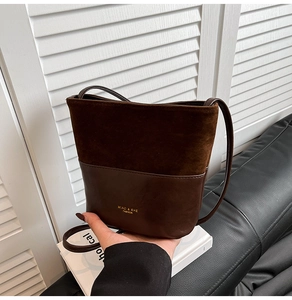 Detail of dark brown bucket bag featuring contrast suede and smooth leather textures