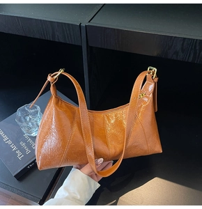 Détail du sac bandoulière en cuir plissé brillant caramel avec boucle en métal doré