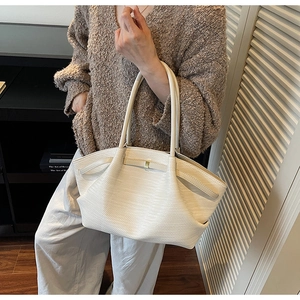Detail of cream large tote bag with woven texture and elegant pleated sides