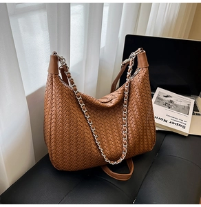Detailed weave pattern on brown leather hobo bag with stylish silver chain strap