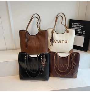 Macro shot of large woven tote bags in four colors with WWTU logo and knot pendant