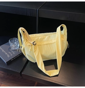 Dettaglio della grande borsa a tracolla in tela giallo pallido con tracolla regolabile e zip
