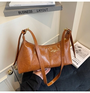 Détail du sac rétro en cuir ciré marron avec texture plissée et bandoulière réglable