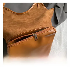 Detail view of the brown leather tote bag interior with a smooth metal zipper pocket