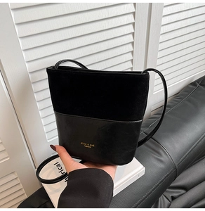 Detail of black bucket bag featuring textured suede and smooth leather patchwork
