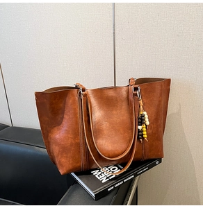 Detail of vintage brown tote bag with smooth texture and decorative colorful wooden beads
