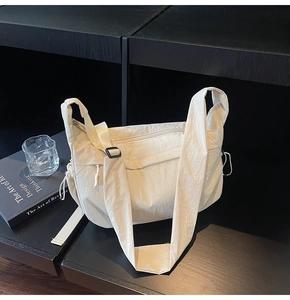 Dettaglio borsa a tracolla in nylon beige chiaro con pieghe e coulisse laterale