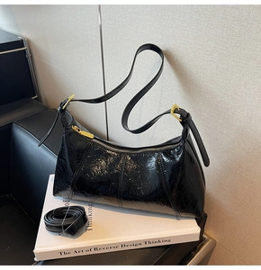 Détail du sac hobo plissé brillant avec boucles dorées et bandoulière réglable