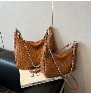 Detail showing two sizes of brown woven leather bags with silver chain and crossbody straps