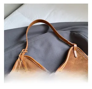 Detail shot of the sturdy brown suede shoulder bag handle and fine stitching craft