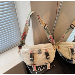 Detail of cream nylon chest bag with colorful floral jacquard wide strap and double zippers
