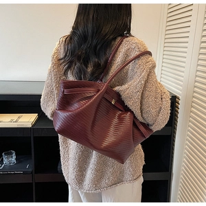 Deep burgundy woven tote bag shown from the back view on model for stylish daily use