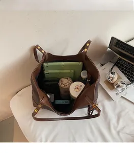 Interior view of large capacity brown tote bag filled with daily office essentials