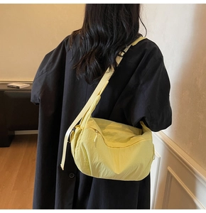 Dettaglio della borsa a tracolla in nylon giallo chiaro con tracolla regolabile e texture