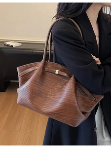 Brown woven tote bag for women featuring a spacious interior and luxury metal buckle detail