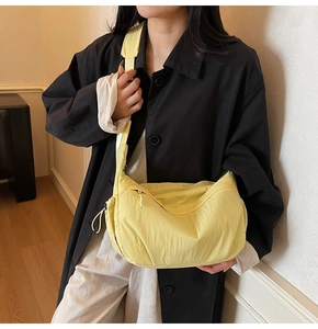 Dettaglio ravvicinato della borsa a tracolla in tela giallo chiaro con coulisse e fascia