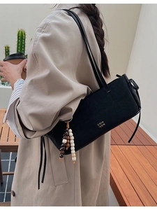 Classic black suede tote bag with gold lettering and decorative wooden bead charm