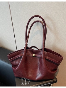 Deep red woven faux leather tote bag with gold metal buckle and dual shoulder straps