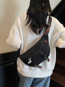 Women's black canvas chest bag with a colorful ethnic style wide jacquard shoulder strap