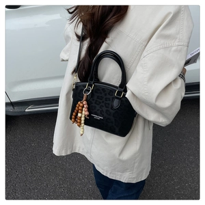 Close-up of leopard print bucket bag with beaded tassel and leather texture detail