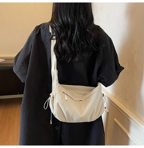 Dettaglio borsa a tracolla in nylon color crema con coulisse e tracolla larga