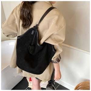 Detail view of large black suede tote bag showing soft texture and premium leather trim