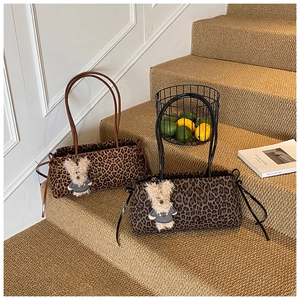 Detalle de bolsos tote con estampado de leopardo en dos tonos y colgantes de conejo