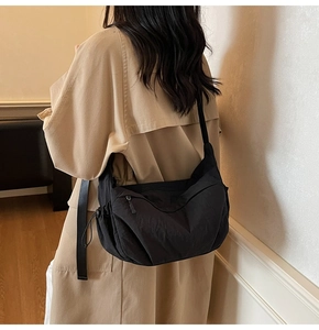 Dettaglio della borsa a mezzaluna in nylon nero indossata per mostrare texture e spazio