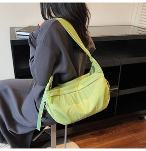 Dettaglio della borsa a tracolla in nylon verde lime con tracolla larga e cerniera lampo