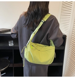 Dettaglio della tracolla regolabile e della zip su borsa a mezzaluna verde neon in tela