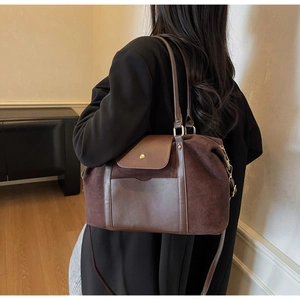 Nahaufnahme der braunen Wildledertasche mit Glattlederbesatz und goldenen Beschlägen