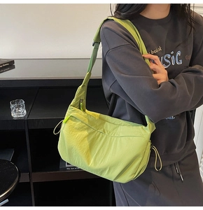 Dettaglio della borsa a tracolla in nylon verde chiaro con coulisse e zip di chiusura