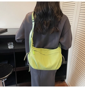 Dettaglio borsa a tracolla in nylon verde lime con tracolla regolabile e tasche zip