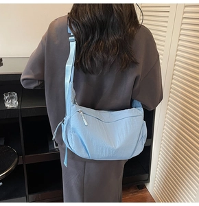 Vista posteriore di una borsa a tracolla azzurra a forma di mezzaluna indossata