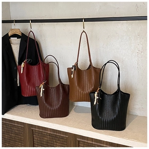Detail of woven tote bags in four colors with wood bead tassels and slim shoulder straps