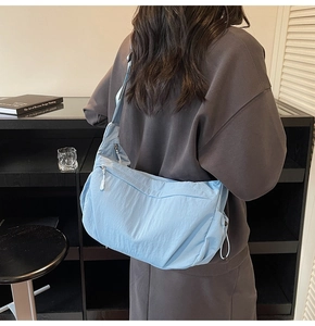 Dettaglio della borsa a tracolla in nylon azzurro con coulisse e tasca con cerniera